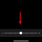 Screenshot of the text size slider in iPhone settings with a red arrow pointing to it.